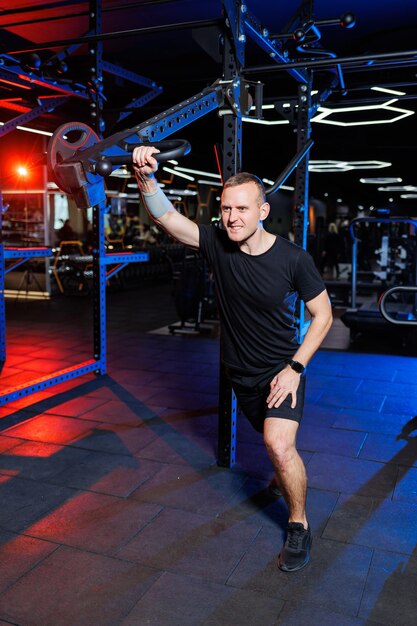 Aantrekkelijke volwassen man die oefeningen doet en gewichten opheft in de sportschool. sporttraining in de sportschool