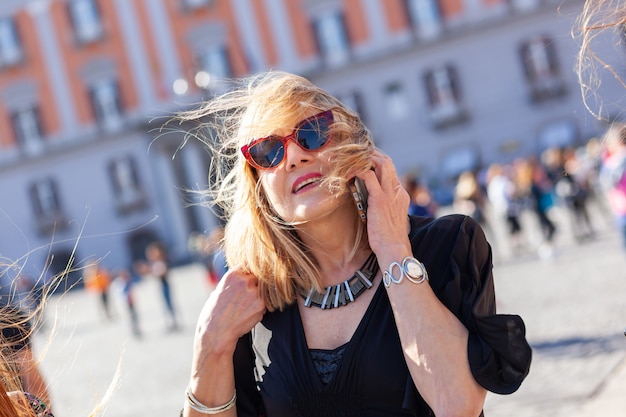 Aantrekkelijke volwassen vrouw spreekt aan de telefoon