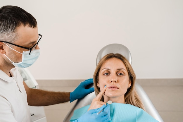 Aantrekkelijke vrouw bang voor tandarts Tandarts raadpleegt bang meisje in de tandheelkunde Behandeling van tanden en kiespijn in de tandheelkunde