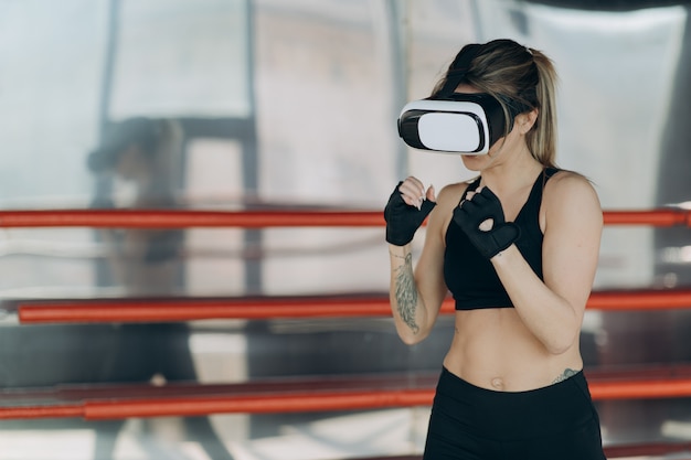 Aantrekkelijke vrouw boksen in VR 360 headset training voor schoppen in virtual reality