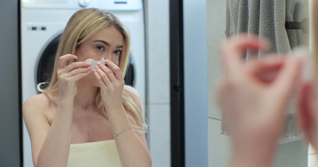 Foto aantrekkelijke vrouw die huidmaskerplasters onder de ogen aanbrengt voor anti-aging cosmetica voor huidverzorging cosmetisch concept spa-behandeling concept