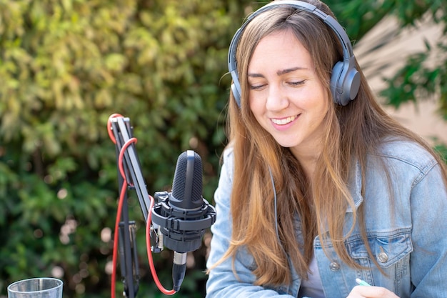 Aantrekkelijke vrouw die radio-podcast opneemt jong meisje dat praat tijdens live stream-sessie buiten