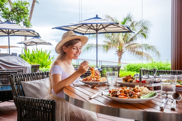 Aantrekkelijke vrouw eet Italiaanse pasta in openluchtrestaurant of café bereid voedsel