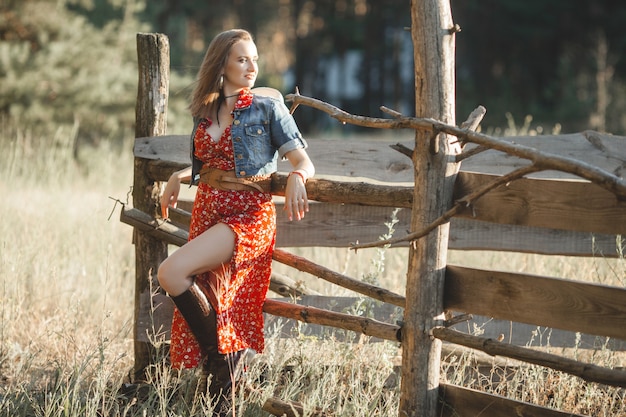 Aantrekkelijke vrouw in een rode jurk op het platteland