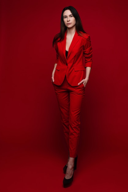 Aantrekkelijke vrouw in rood pak en zwarte hakken