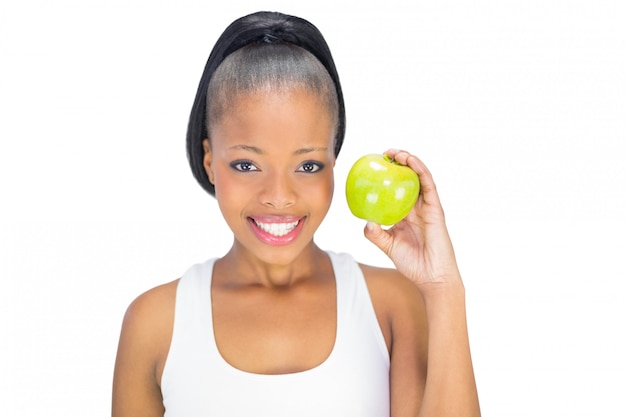 Aantrekkelijke vrouw in sportkleding die groene appel houdt