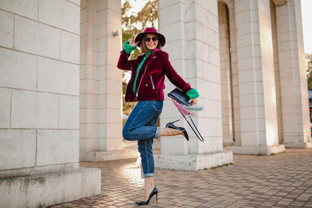 Aantrekkelijke vrouw in trendy outfit in herfststijl die op straat loopt