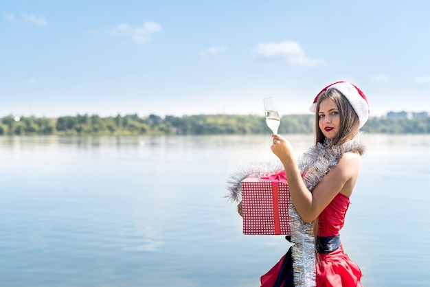 Aantrekkelijke vrouw met geschenkdoos en champagne