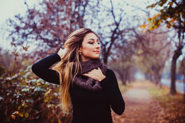 Aantrekkelijke vrouw met gezond lang haar genietend van herfstdag Gezondheids- en schoonheidsconcept