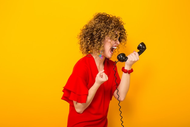 Aantrekkelijke vrouw met kort krullend haar met telefoon