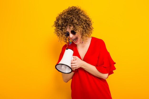 Aantrekkelijke vrouw met krullend haar met luidspreker