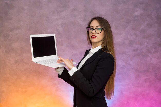 Aantrekkelijke vrouw met witte muurlaptop