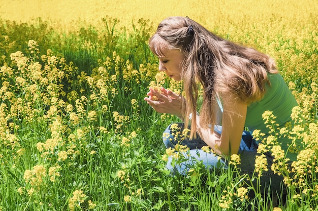 Aantrekkelijke vrouw op gele bloementuin.