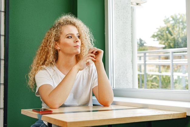 Aantrekkelijke vrouw zitten aan de tafel in cafetaria