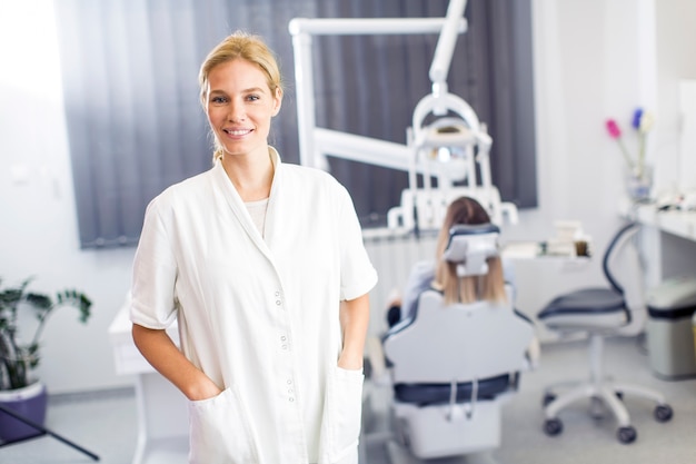 Aantrekkelijke vrouwelijke tandarts poseren in moderne tandheelkundige kantoor