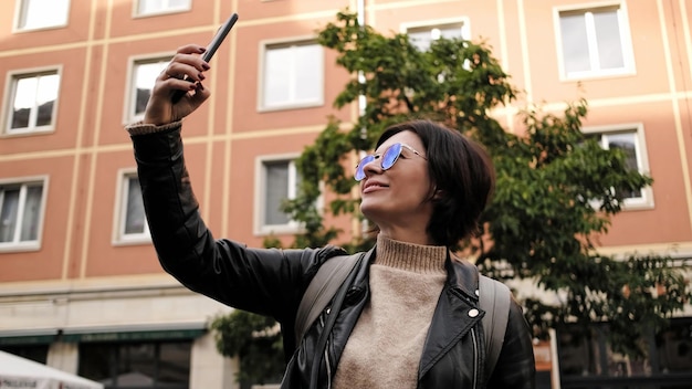 Aantrekkelijke vrouwelijke toerist loopt in het historische centrum van Dresden en maakt een selfie.