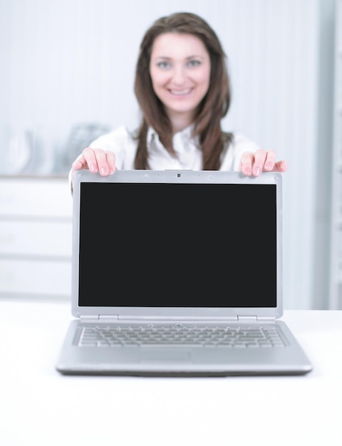 Aantrekkelijke zakenvrouw die een laptop presenteert met copyspace op de monitor