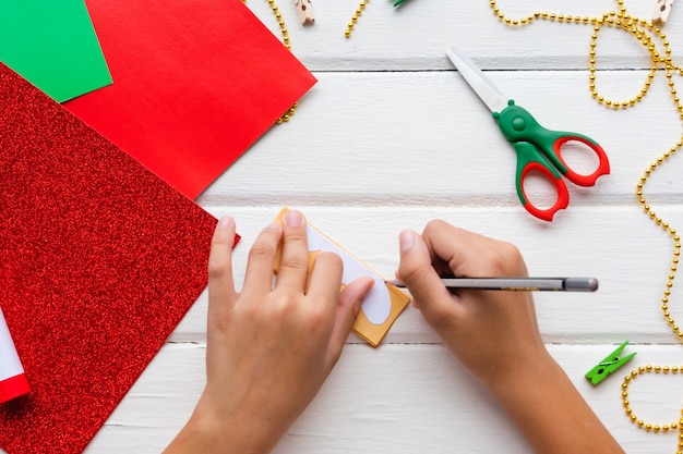 Aanvraag voor kinderen. Kerst- of nieuwjaarskaart met peperkoekman van papier. doe-het-zelf. Instructies.