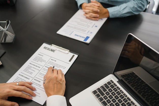Aanwervingsconcept Mannelijke werkgever die tijdens het sollicitatiegesprek het CV van de aanvrager leest