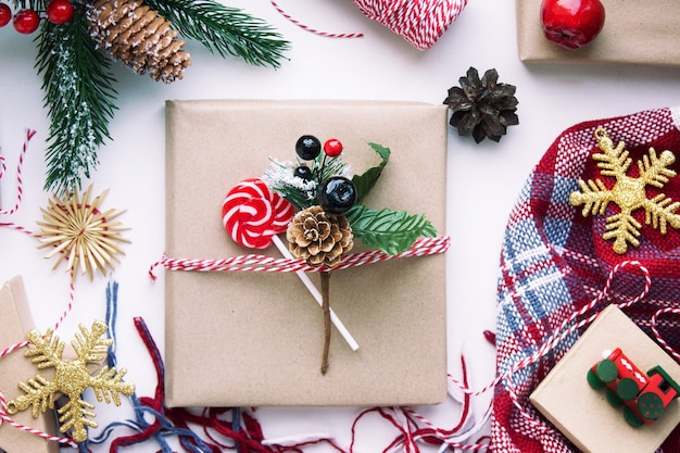 Aanwezig in bruin knutselpapier, dozen, snoep, plaid en kerstversieringen op tafel. voorbereiding op nieuwjaar