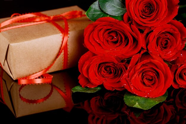 Aanwezig met rood lint en boeket van mooie rode rozen. Moederdag of Valentijnsdag concept.