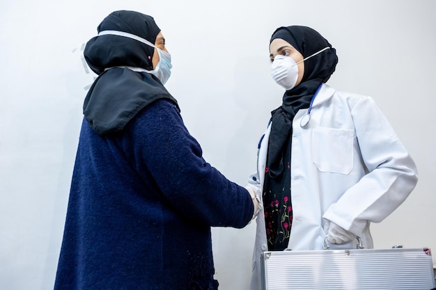 Aarbic muslim doctor daughter shaking hands with her mother