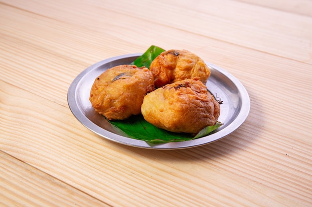 Aardappel Bonda Indiase pittige snack gerangschikt in een stalen plaat bekleed met bananenblad