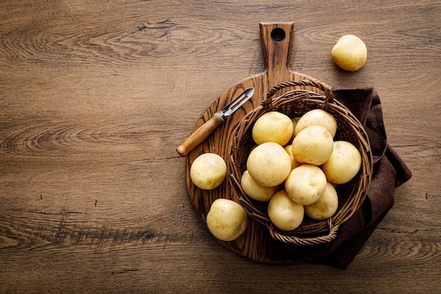 Aardappel in een mand op houten tafelblad bekijken