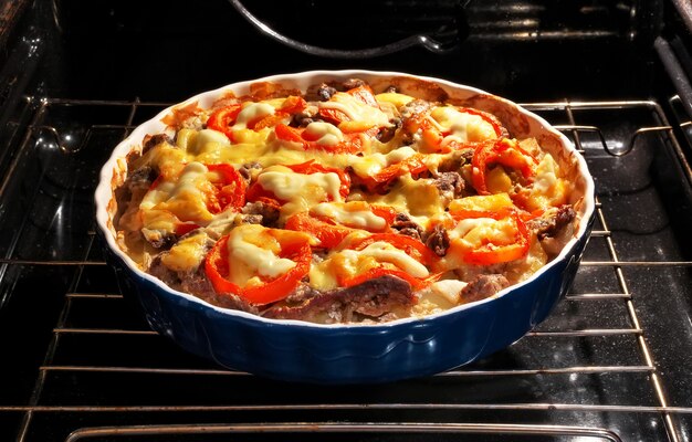 Aardappel met vlees, tomaat en kaas wordt in de oven gebakken. koken met anti-aanbakvorm in de oven