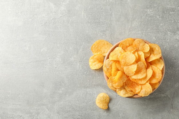 Aardappelchips. Biersnacks op grijs, ruimte voor tekst. Bovenaanzicht