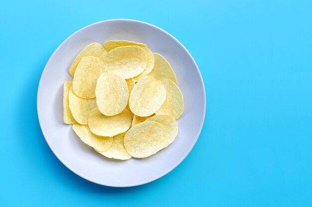 Aardappelchips op blauwe achtergrond. Bovenaanzicht