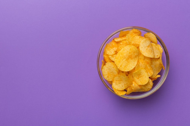 Aardappelchips op kom geïsoleerd op gekleurde achtergrond Heerlijke knapperige aardappelchips in kom Ruimte voor tekst Bovenaanzicht