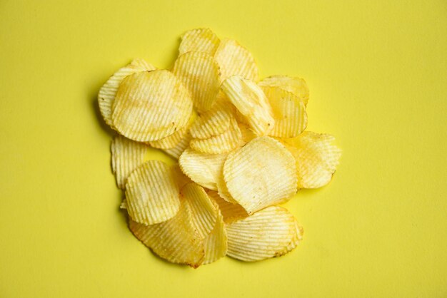 Foto aardappelchips snack op gele achtergrond krispy aardappel top view