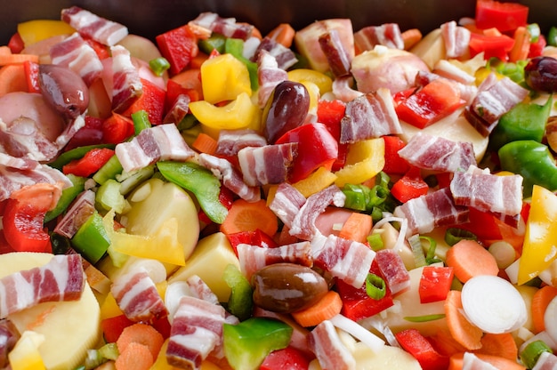 Foto aardappelen gebakken met spek, paprika, wortelen, uien en diverse kruiden en olijven.