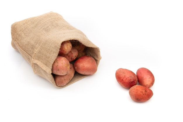Aardappelen geïsoleerd in een jutezak op witte achtergrond