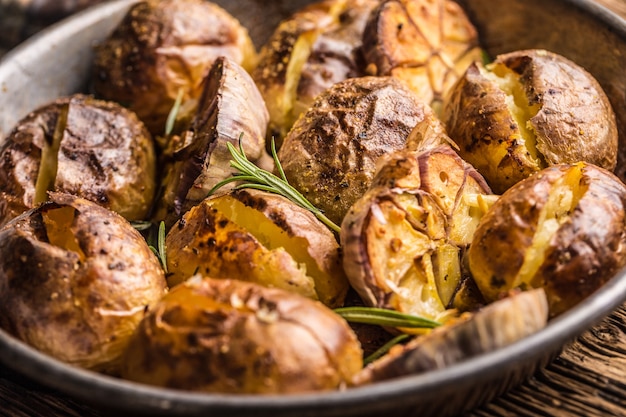 Aardappelen geroosterd met knoflookkruiden en kruiden in vintage pan.