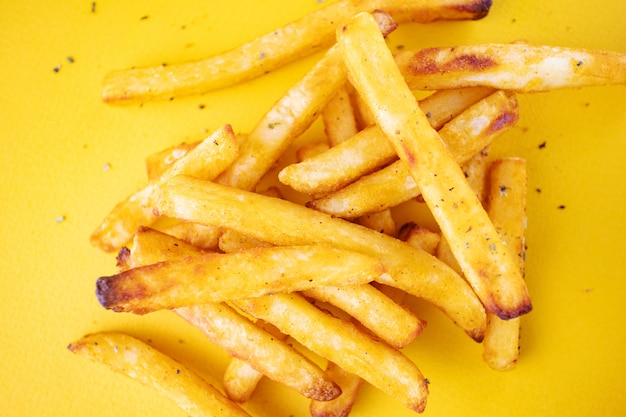 Aardappelen in de schil met aromatische kruiden op een gele achtergrond.