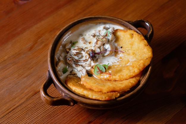 Aardappelpannenkoekjes met champignons en spek in zure roomsaus