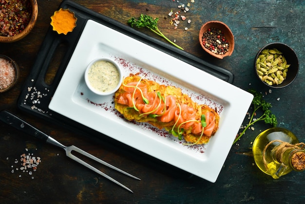 Aardappelpannenkoekjes met zalm en saus op een witte plaat Bovenaanzicht