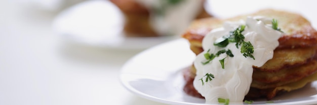 Foto aardappelpannenkoekjes met zure room en kruiden op plaat koken heerlijk ontbijt concept