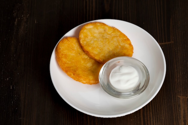 Aardappelpannenkoekjes met zure room op een bord
