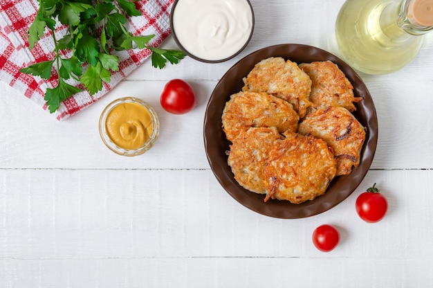 Aardappelpannenkoekjes op een plaat op een witte houten tafel. Vegetarisch menu. Bovenaanzicht