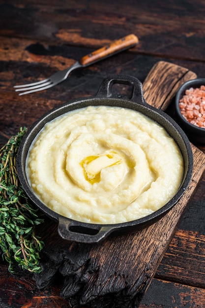 Aardappelpuree in een pan op houten rustieke tafel. Houten achtergrond. Bovenaanzicht.