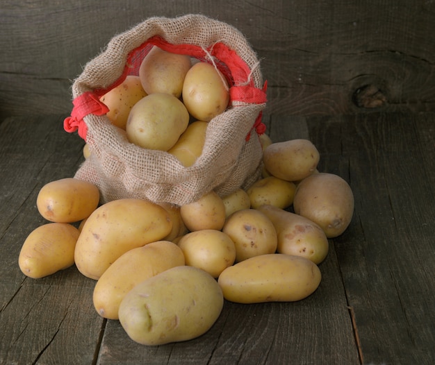 Aardappels op een zakje onder andere aardappelen op rustieke houten achtergrond