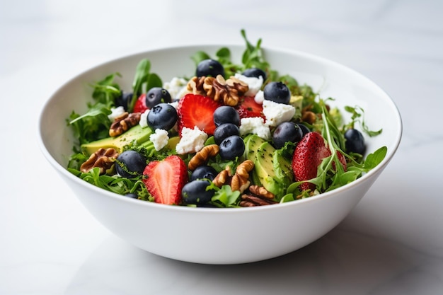 Aardbeersalade met arugula, sla, bosbessen, feta kaas en walnoten op een witte tafel