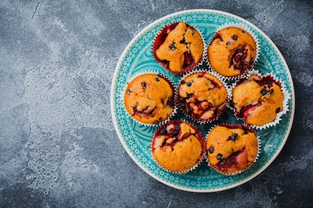 Aardbei chocolade cupcakes muffins op oude houten standaard op betonnen grijze ondergrond