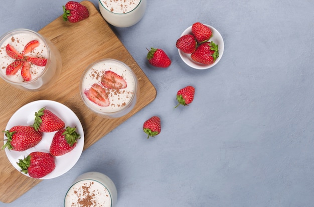 Aardbei dessert in een glazen pot met aardbeien op een grijze tafel met linnen servet