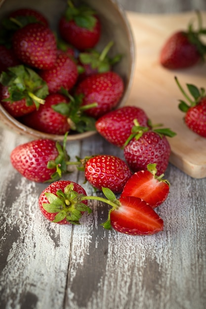 Aardbei in een kom op een houten achtergrond