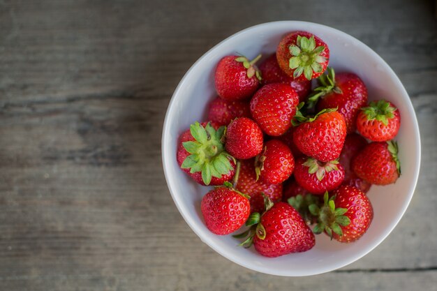 Aardbei in een plaat op een houten achtergrond