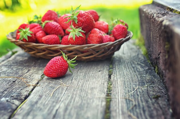 Aardbei in rieten plaat op houten achtergrond